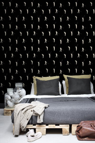 Schlafzimmer mit Bett vor einer Tapete mit Golfmotiven