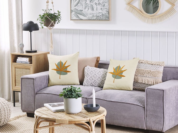 Wohnzimmer mit Sofa, Kissen und Couchtisch im hellen Design.