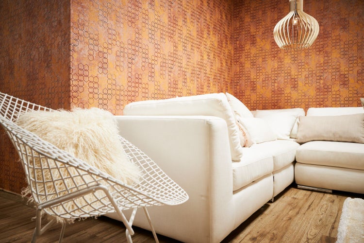 Wohnzimmer mit Sofa, Stuhl, Kissen, Tapete und Lampe