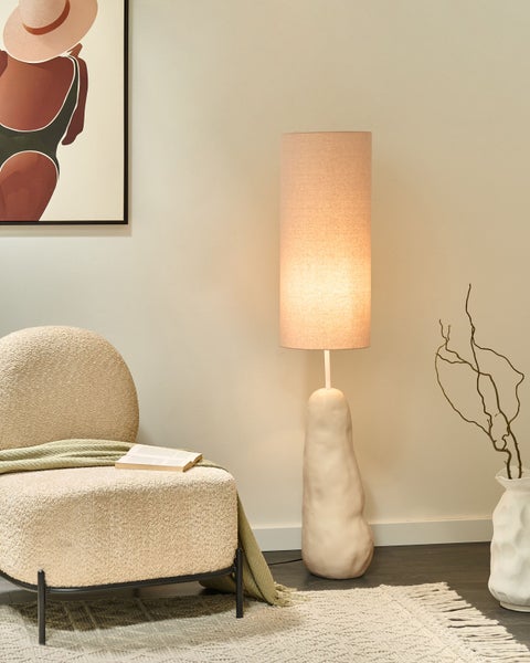 Atmosphärisches Interieur mit Sessel, Stehlampe und Dekoration