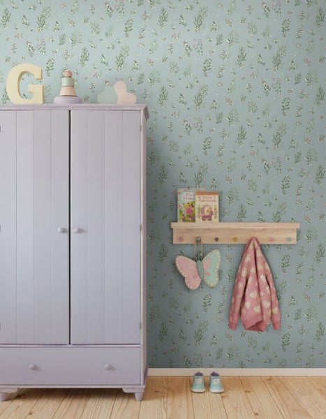 Vliestapete mit botanischem Muster aus Pflanzen und Vögeln im hellen Kinderzimmer mit weißem Metallbett und dekorativen Kissen.