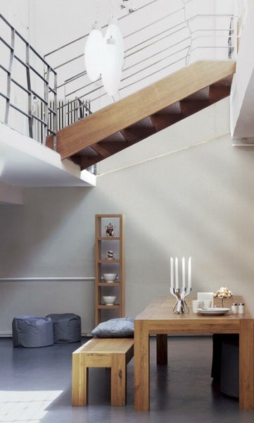 Wohnzimmer mit floral gemusterter Tapete, Sofa und Zimmerpflanze