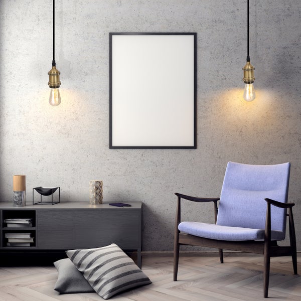 Wohnzimmer mit Sessel, Kommode, Lampe und Bilderrahmen