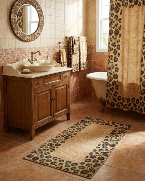Rustikales Badezimmer mit Waschtisch aus Holz, freistehender Badewanne und Textilien mit Leopardenmuster und Kirschmotiven.