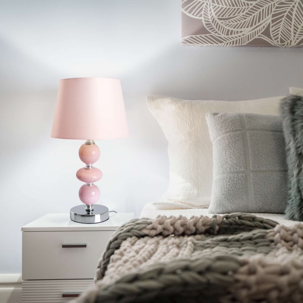 Dekoratives Schlafzimmerambiente mit Nachttischlampe auf dem Nachttisch