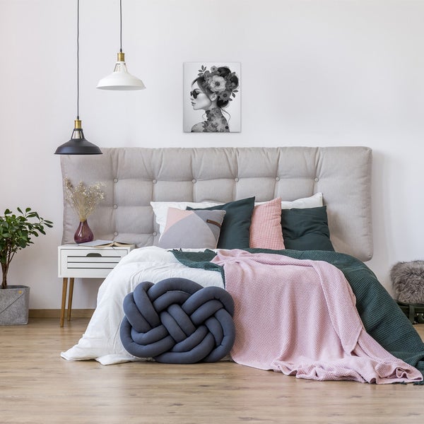 Schlafzimmer mit Bett, Nachttisch und dekorativer Wandkunst