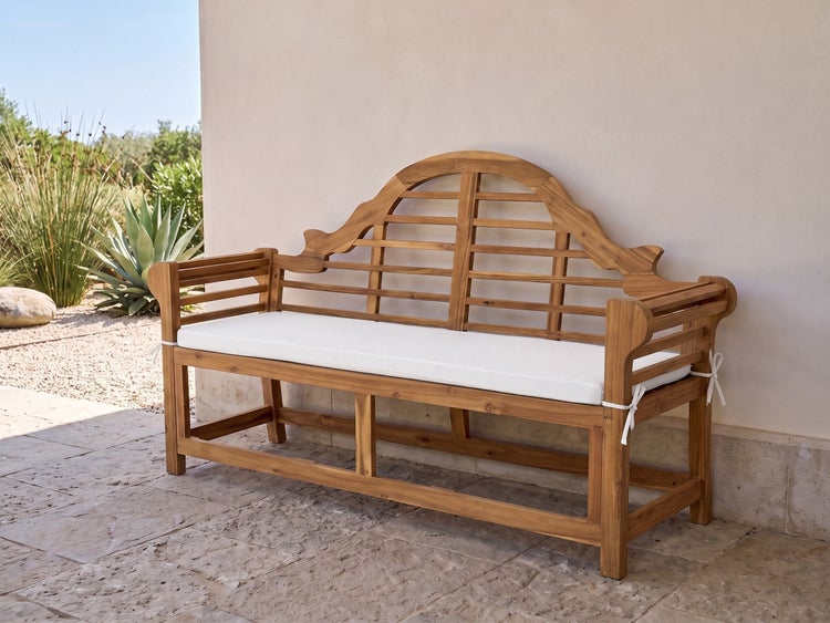 Gartenbank aus Holz mit geschwungener Rückenlehne und Sitzpolster auf einer Terrasse.