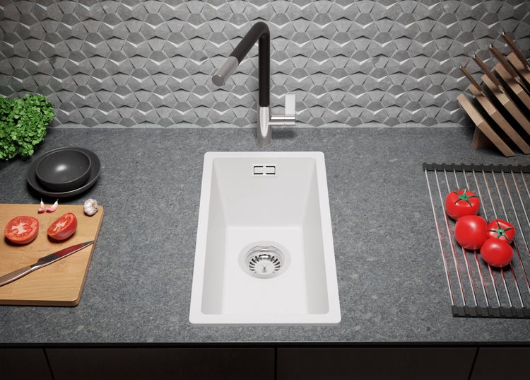 Küchenszene mit Spüle, Armatur und Lebensmitteln auf einer Arbeitsplatte.