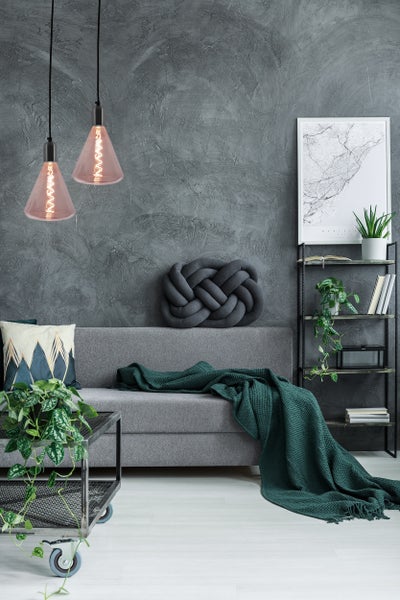 Wohnzimmer mit Sofa, Regal und Hängelampe mit drei Lampenschirmen