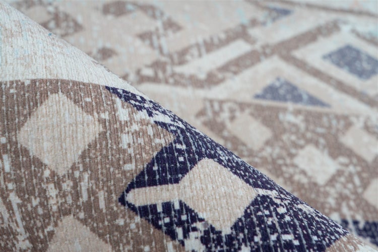 Detailaufnahme eines Teppichs mit geometrischem Muster und sichtbarer Webstruktur.