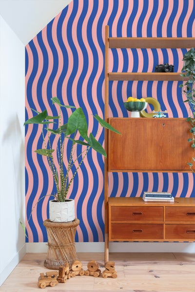 Dekoratives Zimmer mit gemusterter Tapete, Regal und Zimmerpflanze.