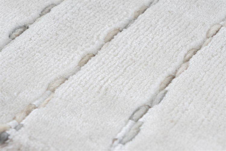 Detailansicht eines Teppichs mit strukturierter Streifenoptik und weicher Oberfläche.