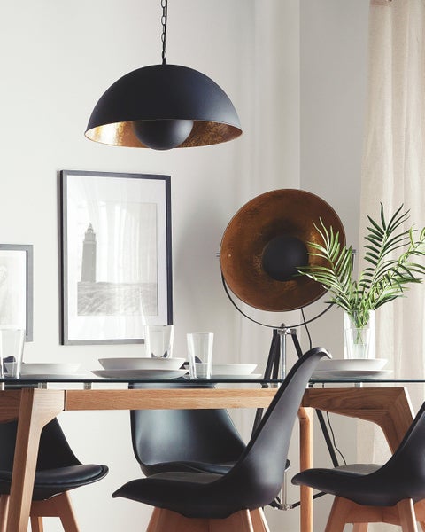Esstisch mit Stühlen, Geschirr, Pendelleuchte und Stehlampe für eine helle, organisierte Atmosphäre