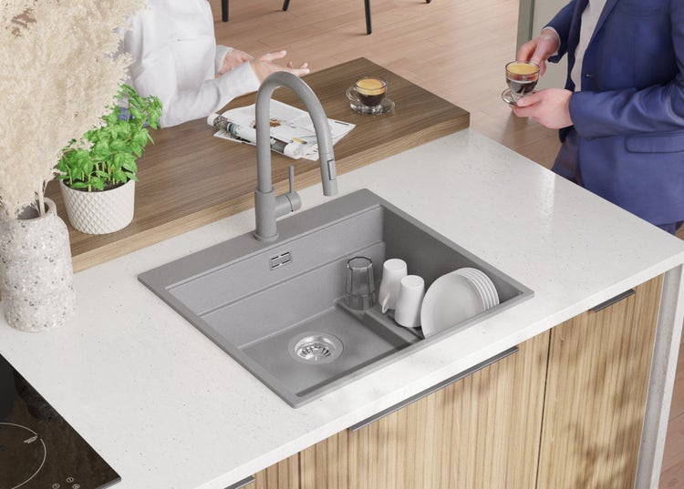 Küchenspüle mit Armatur auf einer Arbeitsplatte mit Geschirr