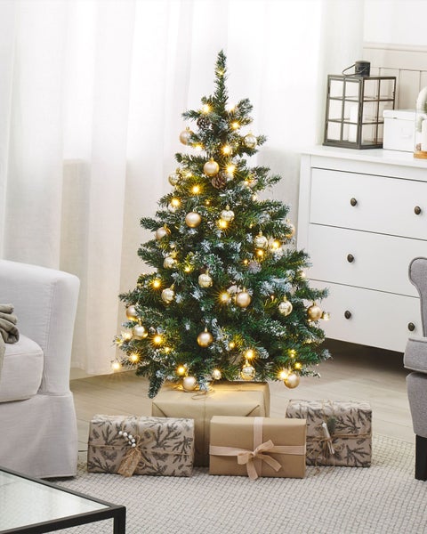 Dekorierter Weihnachtsbaum mit Geschenken im Wohnzimmer