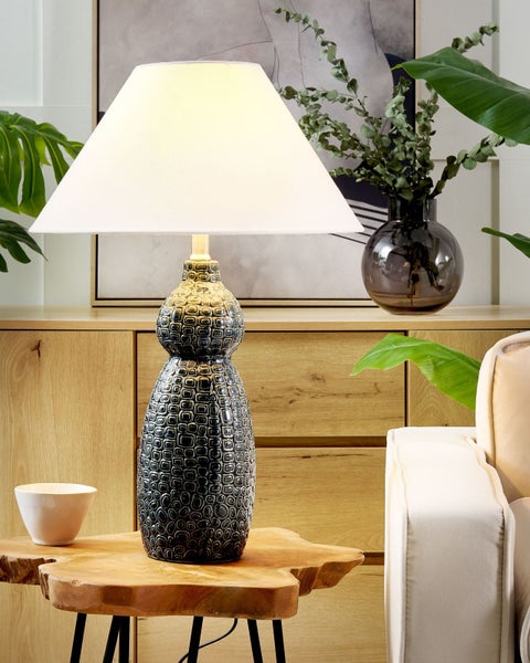 Dekorative Tischleuchte mit Lampenschirm auf einem Holztisch