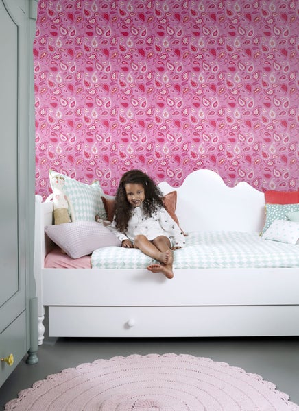 Kinderzimmer mit Bett, Kissen und gemusterter Tapete