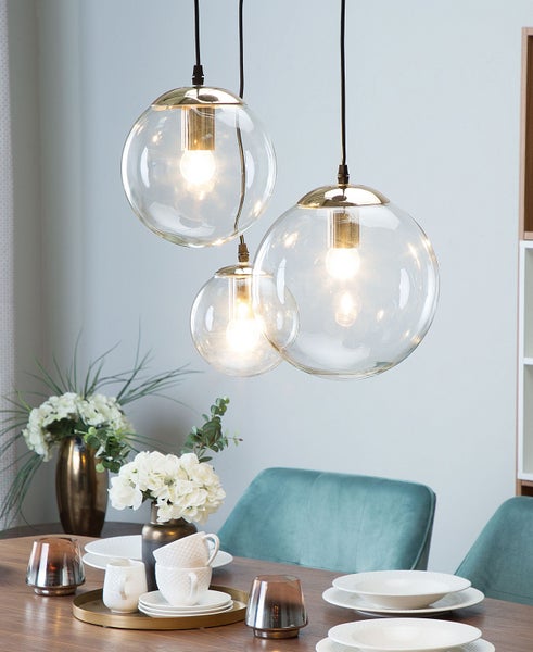 Szene mit Esstisch und drei Kugelpendelleuchten