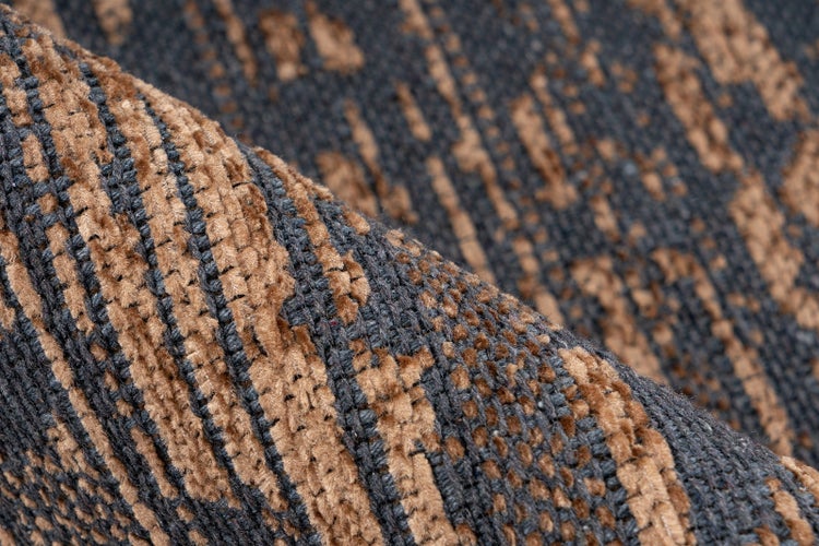 Nahaufnahme eines gemusterten Teppichs mit gewebter Struktur und abstraktem Design.