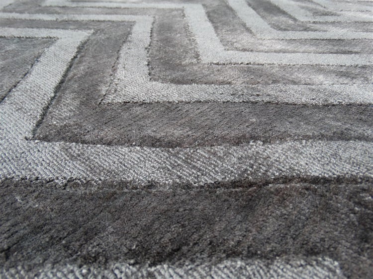 Teppich mit grauem Zickzack-Muster und unterschiedlichen Florhöhen.