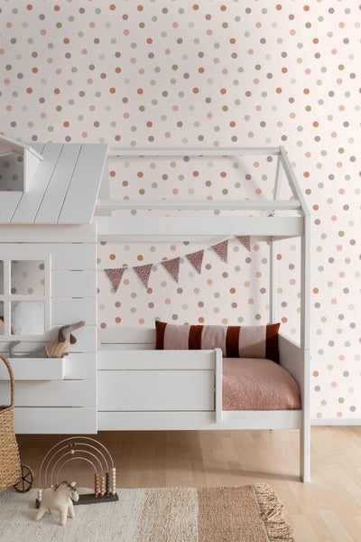 Kinderzimmer mit weißem Hausbett, gemusterter Tapete und Spielzeug