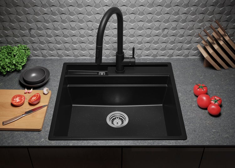 Schwarze Küchenspüle mit Wasserhahn, Schneidebrett und Tomaten