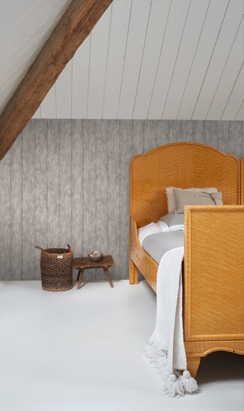 Schlafzimmer mit Holzbett, Holzbalken, Holzwand, Korb und Hocker