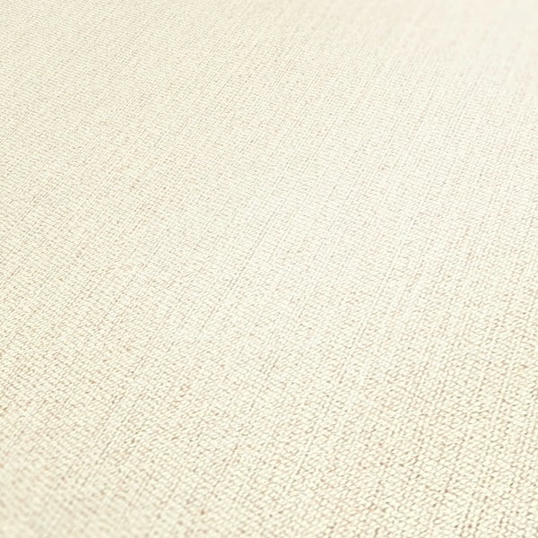 Zwei graue Sessel mit Kissen, ein runder Tisch mit Pflanze und ein Spiegel in einem hellen Raum.