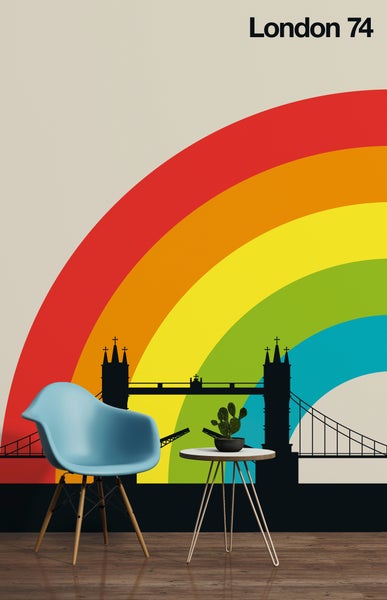 Fototapete mit der Silhouette der Londoner Tower Bridge und einem Regenbogen in einem modernen Zimmer mit Stuhl und Beistelltisch.