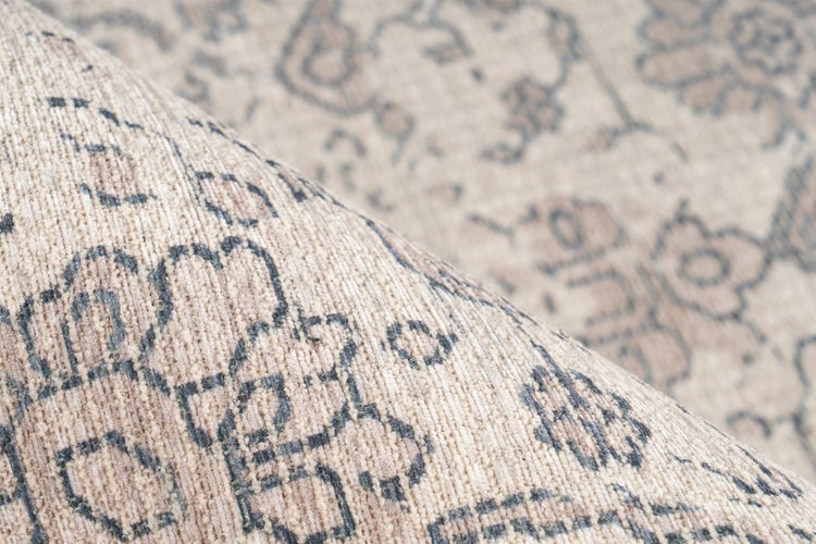 Nahaufnahme eines gewebten Teppichs mit traditionellem orientalischem Muster und floralen Motiven.