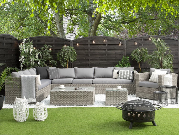 Gartenlounge mit Flechtoptik, Couchtisch und Feuerstelle im Garten