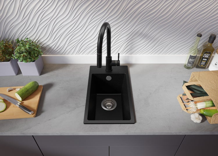 Schwarzes Küchenspülbecken mit Wasserhahn auf einer Küchentheke mit Lebensmitteln