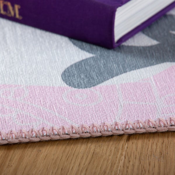 Detailansicht eines gemusterten Teppichs mit geketteltem Rand auf Holzboden, zeigt die strukturierte Oberfläche.