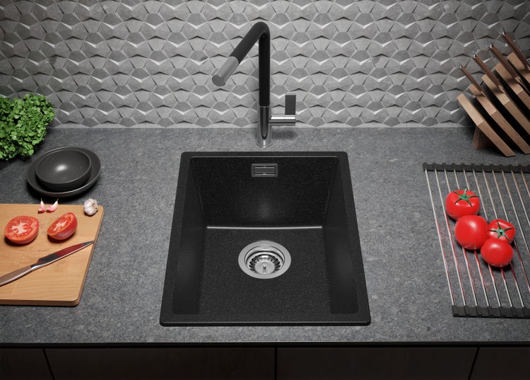 Küchenspüle aus Granit mit Abtropfgestell und Armatur auf einer Arbeitsplatte