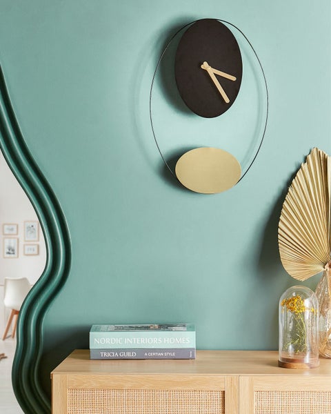 Dekoratives Zimmer mit Wanduhr, Spiegel und Kommode