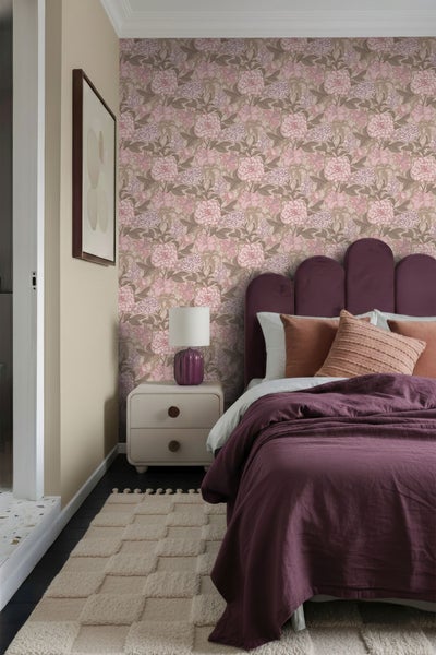 Schlafzimmer mit floraler Tapete, Bett, Nachttisch und Teppich