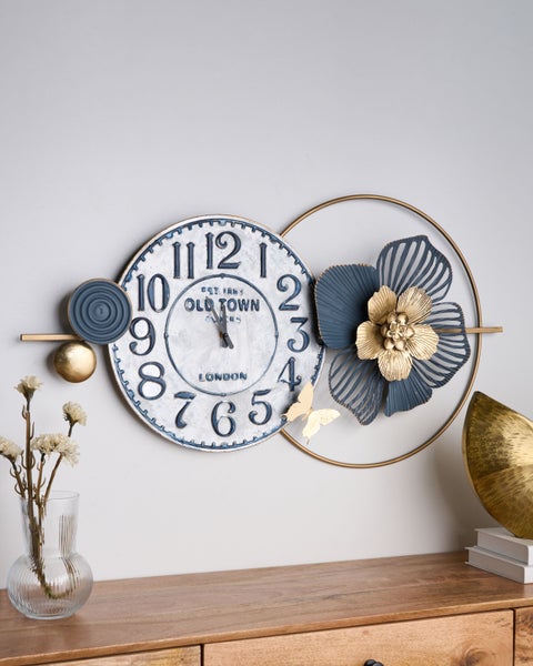 Dekorative Wanduhr aus Metall mit floralen Elementen und Schmetterling im Vintage-Stil.