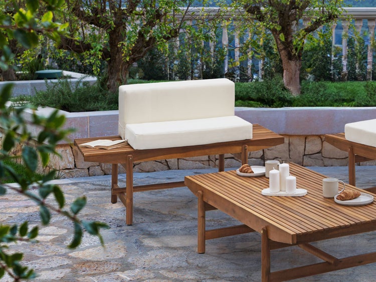 Gartenszene mit Holzmöbeln und Sitzkissen auf Terrasse