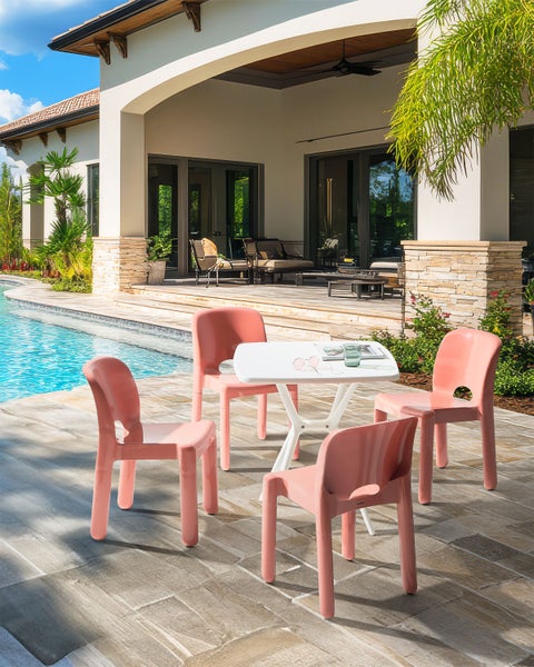 Gartenszene mit Gartentisch und vier Gartenstühlen auf einer Terrasse am Pool
