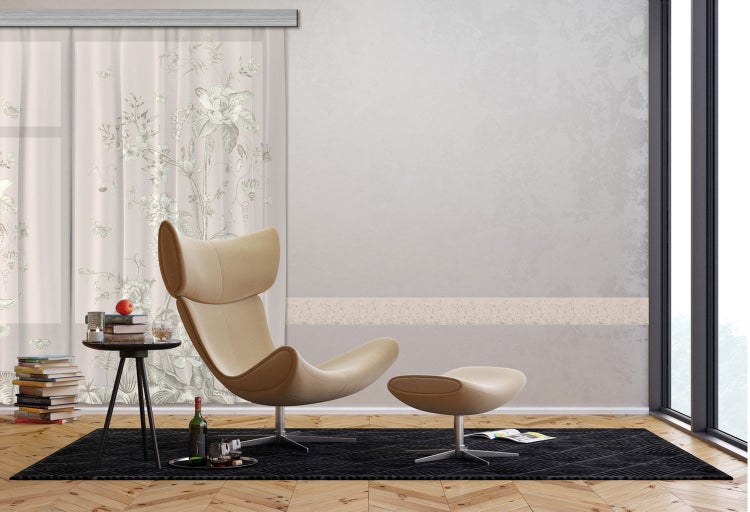 Wohnzimmer mit Sessel, Hocker, Teppich, Vorhang und Beistelltisch