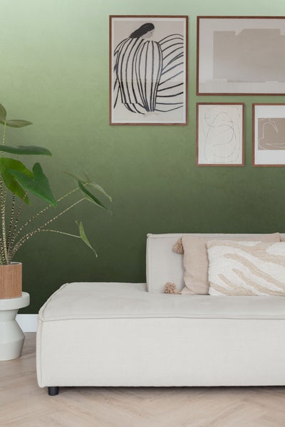 Wohnzimmer mit Couch, Kissen, Pflanzen und Wandbildern für die Inneneinrichtung