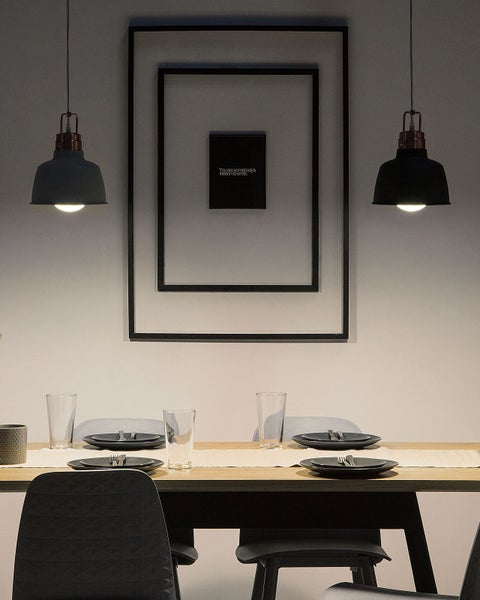 Esstisch mit Geschirr und zwei Hängelampen über dem Tisch