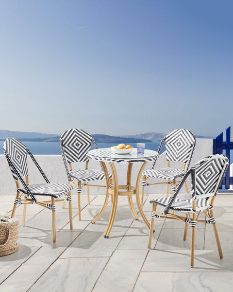 Terrassenszene mit Tisch und vier Stühlen, ausgestattet mit Obst und Wasserglas