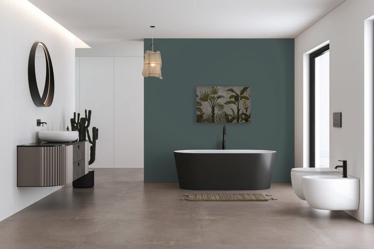 Modernes Badezimmer mit freistehender Wanne, Waschtisch mit Aufsatzwaschbecken, wandhängendem WC und Bidet vor einer dunklen Akzentwand.
