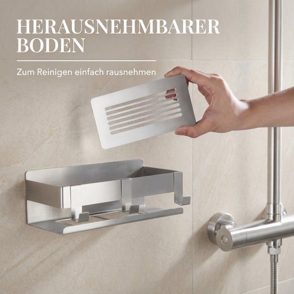 Duschablage aus Edelstahl mit herausnehmbarem Boden zur einfachen Reinigung, montiert an einer gefliesten Wand.