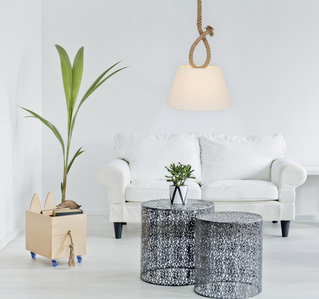 Wohnzimmer mit Sofa, Beistelltischen, Hängelampe und Zimmerpflanze