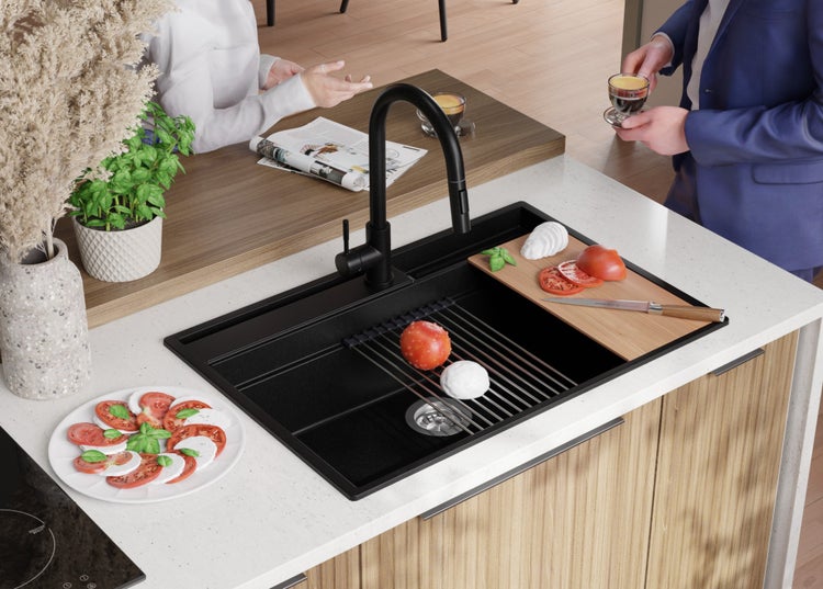 Spüle mit Abtropfgitter, Schneidebrett, Armatur und Lebensmitteln auf einer Küchentheke