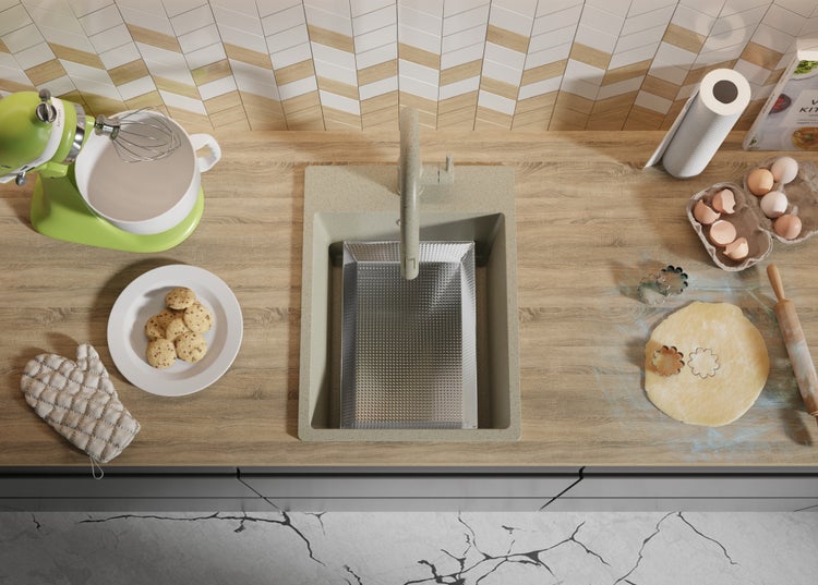 Küchenszene mit Spüle, Armatur, Rührgerät, Keksen, Eiern und Teig auf einer Arbeitsplatte