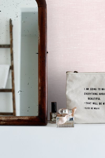 Dekorative Anordnung mit Spiegel, Nagellack, Parfüm und Kosmetiktasche auf einem Regal