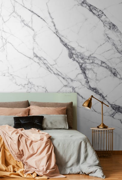 Schlafzimmer mit Bett, Nachttischlampe und Marmorwand